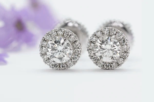 A pair of round diamond halo stud earrings