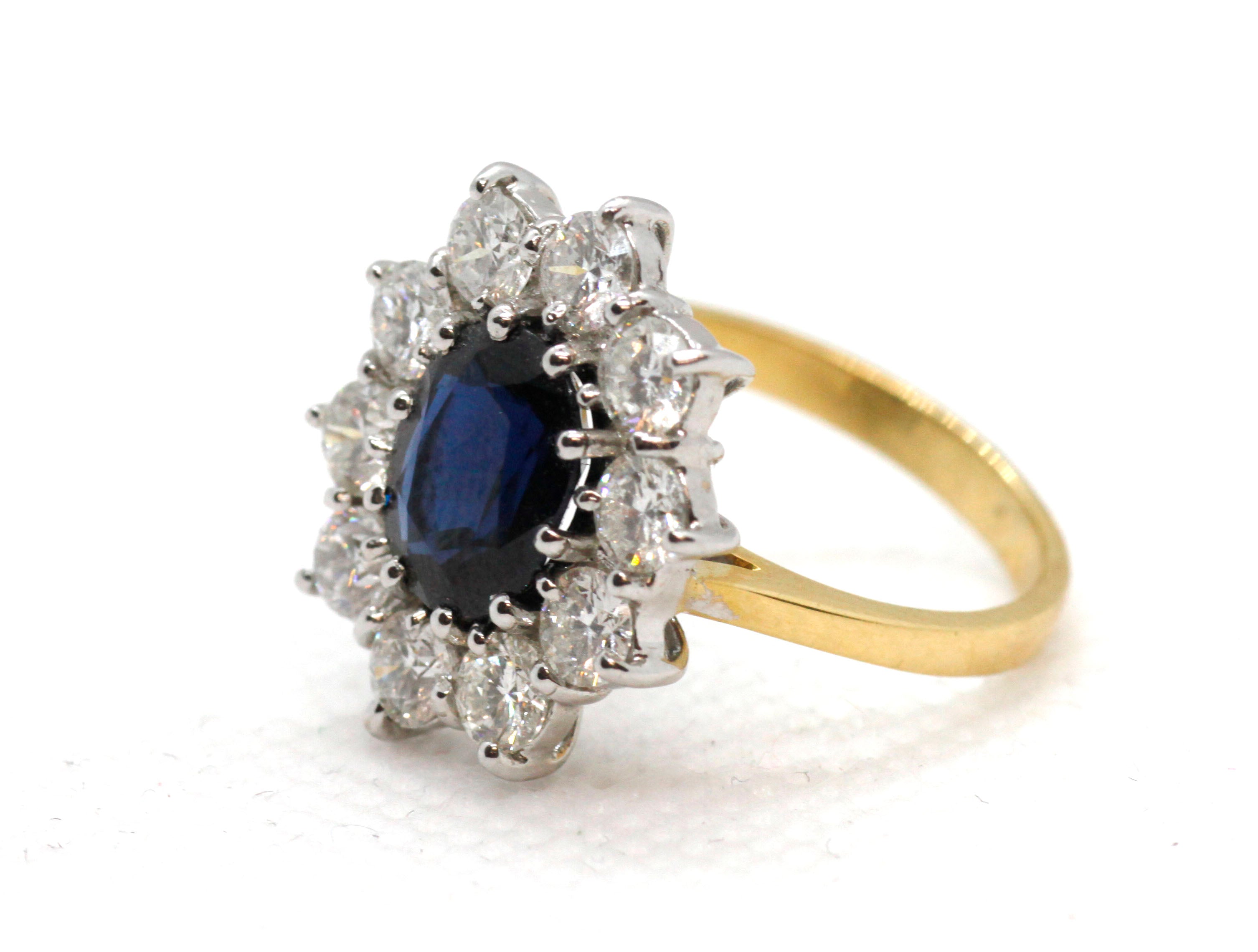 Yellow gold ring with a sapphire centre and a halo of diamonds