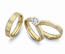 Three yellow gold wedding and engagement rings, one with a diamond solitaire